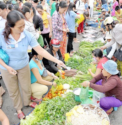 Workers buy vegetables at a market in HCMC (Photo: SGGP)